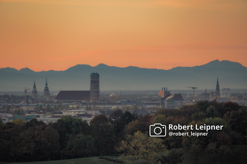 Stadtpanorama von München am Abend mit Alpen im Hintergrund