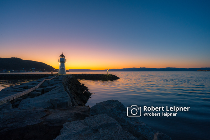 Sonnenuntergang an einer Hafenanlage mit Leuchtturm in Trondheim