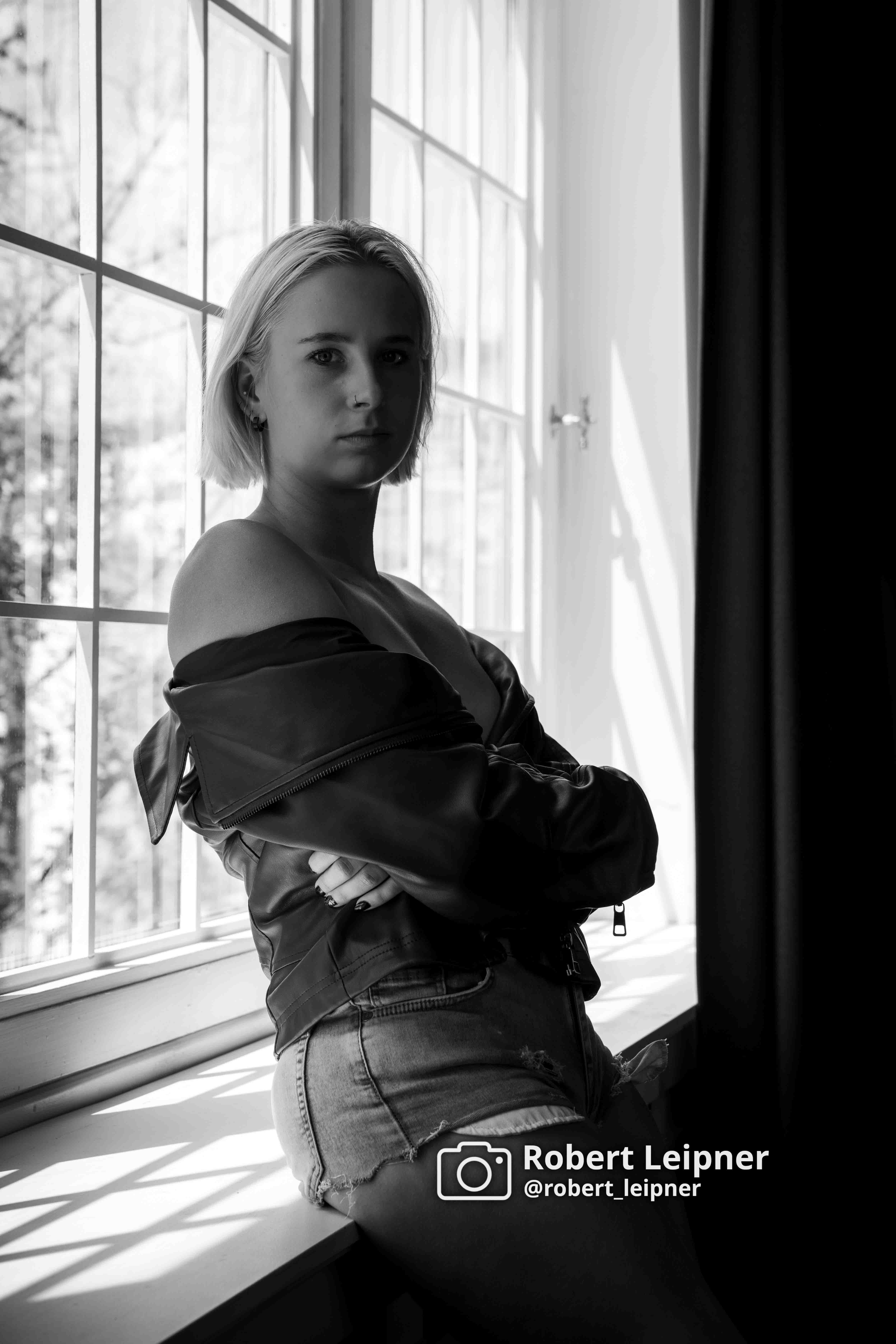 sensual Aufnahme eines Models am Fesnter in schwarz-weiß